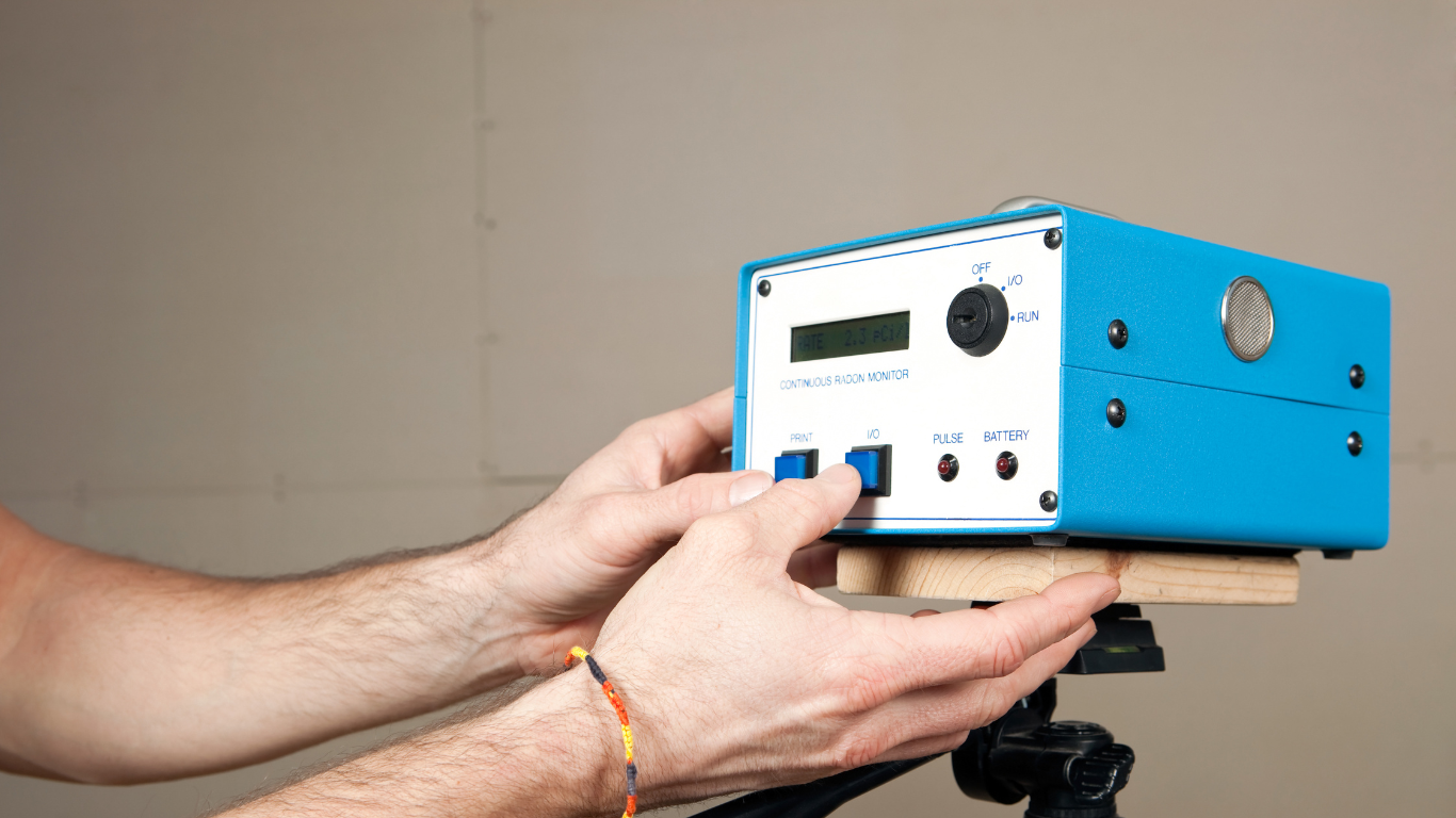 A person using a continuous radon monitor device for radon testing in a home environment.