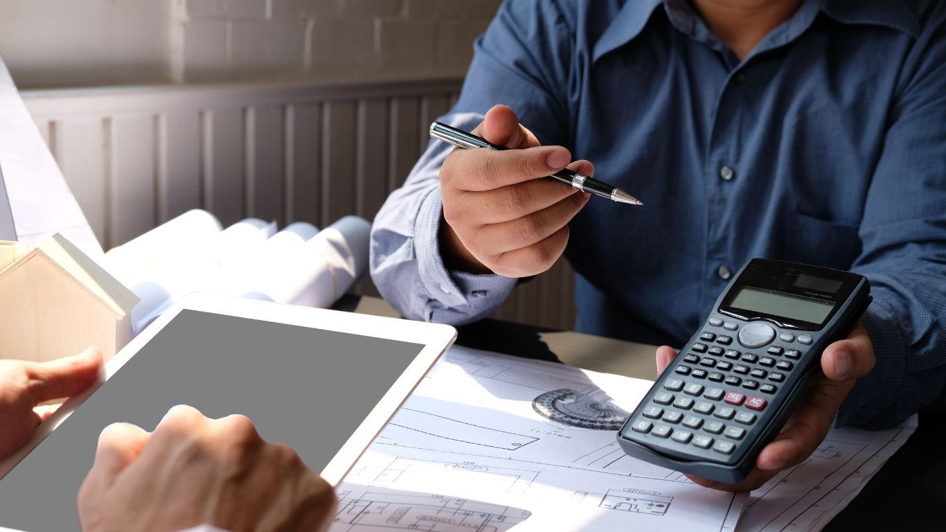 What You Need to Know About the Cost of Water Damage Restoration in Derry NH Man showing calculator to a person with an iPad